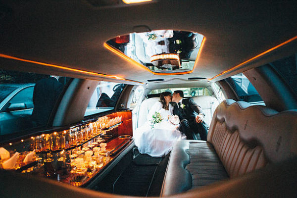 just married: Bride and groom kissing in a stretch limousine